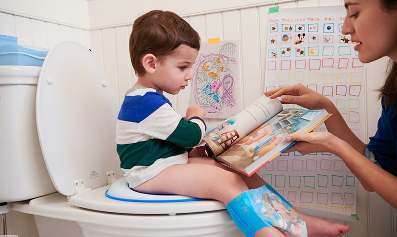 Enfant sur le pot lisant un livre pour enfants